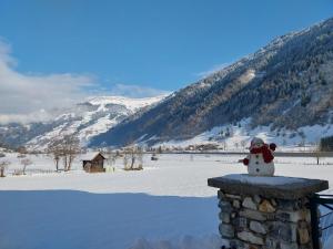 a snowman sitting on top of a stone wall at Studio Dorfblick in Dorfgastein in Dorfgastein +2 photos