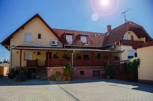 a house with a porch and a balcony at Arany Patkó Panzió in Debrecen