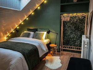 a bedroom with a bed and a window with lights at Chambre et salle de bain privative in Liège