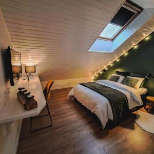 a bedroom with a bed and a desk and a skylight at Chambre et salle de bain privative in Liège +20 photos