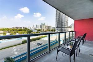 Un balcón con sillas y vista a la ciudad. en Luxury Suite on Beachwalk with Pool Gym & Beach, en Hallandale Beach