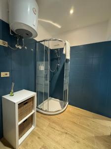 een douche in een badkamer met een blauwe muur bij Suite San Giovanni in Rome
