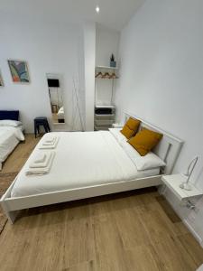 een slaapkamer met een groot wit bed met gele kussens bij Suite San Giovanni in Rome