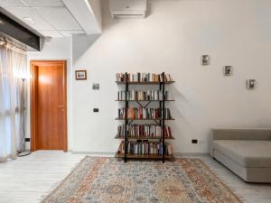 a living room with a book shelf filled with books at Two-room apartment in Segrate - Comfort, 10 minutes from Milano, Cortina 2026 Winter Olympics in Segrate +11 photos