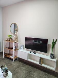 a living room with a tv on a white entertainment center at Real .Departamento in Luján