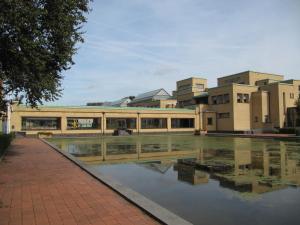 a building with a reflection in a body of water at Bed & Breakfast Obrechtstraat in The Hague
