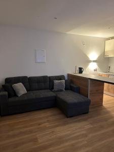 Una sala de estar con un sofá y una cocina. en Innsbruck home, en Innsbruck