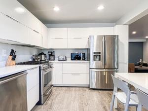 a kitchen with white cabinets and a stainless steel refrigerator at Relax and Play, 2BR Close to SoFi, LAX - SH1-LAD in Los Angeles