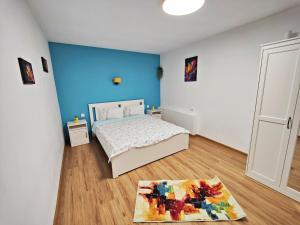 a bedroom with a bed and a blue wall at Casa De Sub Padure in Bran