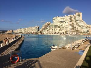 un grande edificio accanto a uno specchio d'acqua con edifici di San Alfonso Apartment ad Algarrobo