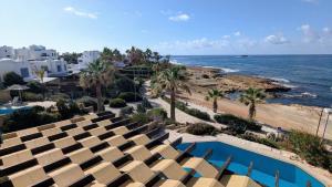 eine Luftaufnahme eines Resorts mit Swimmingpool und Meer in der Unterkunft Villa Galatea Stunning First Line Beachfront in Klorakas