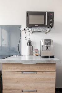 a kitchen counter with a microwave and a coffee maker at petit cocon in Créteil