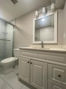 a bathroom with a toilet and a sink and a mirror at CozyHaven A private entrance, comfy basement apartment in Mississauga with free parking Conveniently located with easy access to the airport downtown Toronto major malls and highways for a seamless stay in Mississauga