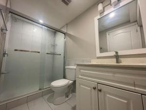 a bathroom with a toilet and a glass shower at CozyHaven A private entrance, comfy basement apartment in Mississauga with free parking Conveniently located with easy access to the airport downtown Toronto major malls and highways for a seamless stay in Mississauga +19 photos