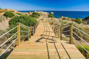 a wooden staircase leading down to the beach at Kimpton Atlantico Algarve by IHG in Albufeira