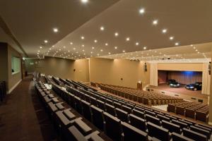 an auditorium with chairs and a car on a stage at Kimpton Atlantico Algarve by IHG in Albufeira