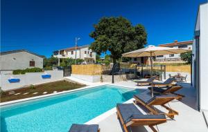 a swimming pool with two chairs and an umbrella at Villa My Hana in Pula +50 photos