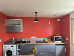 a red kitchen with a sink and a microwave at Ô Vive Studio in Monnetier-Mornex +12 photos