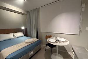 a hotel room with a bed and a table with plates on it at Ap Luxury Pamplona MASP Cd 206 in Sao Paulo