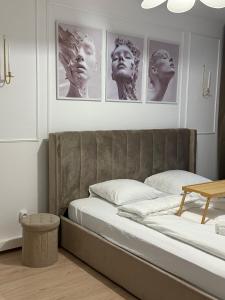 a bedroom with a bed with four pictures on the wall at HomeyHome Strasbourg in Schiltigheim