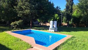 a swimming pool in the grass with a chair next to it at Refugios del Alma in Villa Las Rosas