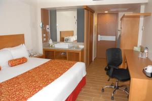 a hotel room with a bed and a desk and a sink at Aranzazu Centro Historico in Guadalajara