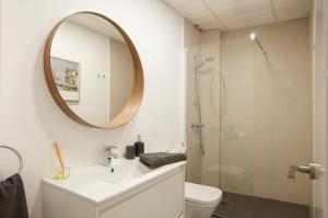 Un baño con lavabo, espejo e inodoro. en Apartamentos Uncibay Premium, en Málaga