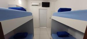 two beds in a room with blue beds and a television at Casa temporada Araçoiaba in Araçoiaba