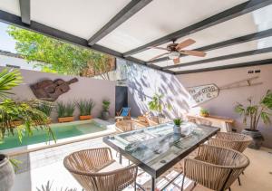 a patio with a glass table and chairs and a pool at Casa Balada Santa Lucía with Parking by Cercana in Mérida