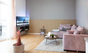 a living room with a couch and a tv at MiCasa OL - Modernes Penthouse - Stellplatz - Küche - WLAN - Dachterrasse in Oldenburg