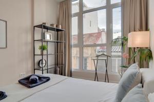a bedroom with a bed and a large window at Apartamentos Uncibay Premium in Málaga