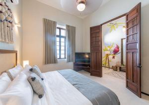 a bedroom with a large bed and a piano at Casa Balada Santa Lucía with Parking by Cercana in Mérida +23 photos