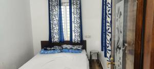 a bedroom with a bed with blue and white accents at Sandy 4 Bhk Homestay - Only Adults Allowed in Ooty