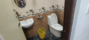 a small bathroom with a toilet and a sink at Sandy 4 Bhk Homestay - Only Adults Allowed in Ooty +20 photos