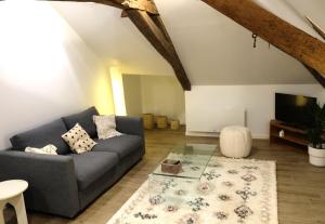 a living room with a couch and a tv at La Citadelle Endormie à Ombrée d'Anjou in Pouancé