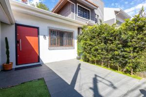 a red door on a house with a yard at Casa Completa com garagem in Curitiba