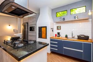 a kitchen with a stove and a counter top at Casa Completa com garagem in Curitiba