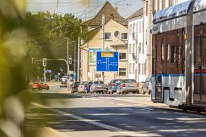 a city street with cars and a bus on the road at JAKSE-Apartments - Urban Jungle - top Lage & flexibler Checkin in Bochum