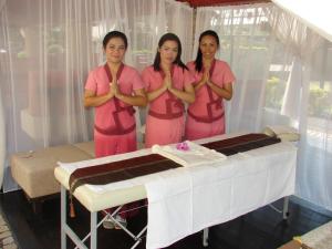 three women standing in front of a table with a cake at Therma Nea Dunajská Streda in Dunajská Streda