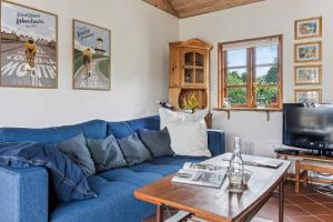 a living room with a blue couch and a table at Holiday Home Exuding Coziness And Comfort in Broager