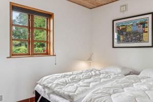 a white bedroom with a bed and a window at Holiday Home Exuding Coziness And Comfort in Broager