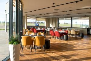 a restaurant with tables and chairs and windows at MG Restaurace/Luxury Apartments in Mladá Boleslav