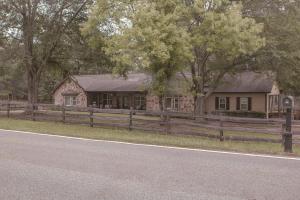 a house on the side of a road next to a fence at Bustamante Ranch - Sovereign Lodge in McDonough
