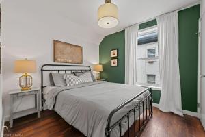 a bedroom with a bed and a green wall at 4 Bedroom Luxury House, Free Parking, Next to LRT, Kitchener Downtown, near Chicopee Ski Club in Kitchener
