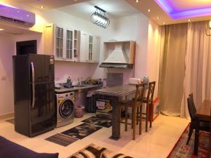 a kitchen with a table and a stove and a refrigerator at Sharm El Sheikh nema downtown apartment in Sharm El Sheikh