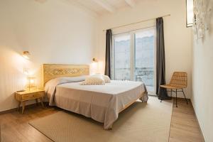 een slaapkamer met een bed en een groot raam bij Apartment Mare di Spartaia in Procchio