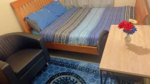 una camera da letto con un letto e un tavolo con un vaso di fiori di Ruby Rooms a Slough