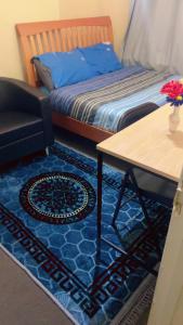 un soggiorno con letto, tavolo e sidro. di Ruby Rooms a Slough