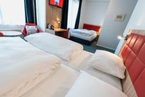 Rúm í herbergi á Prinsen Hotel