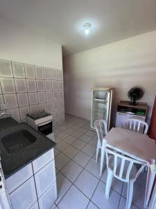 a kitchen with a table and chairs and a stove at Pousada Iguape Apartamentos - Ilha Comprida in Ilha Comprida